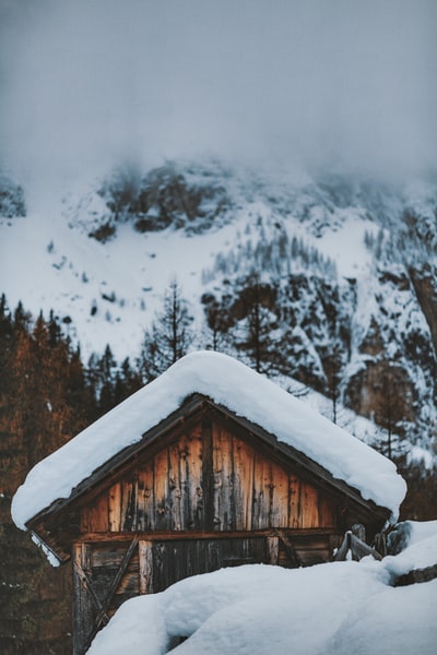 棕色的木头房子在冰雪覆盖的地面
